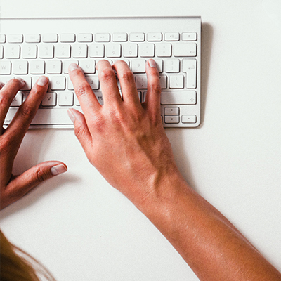 Hands typing on a keyboard