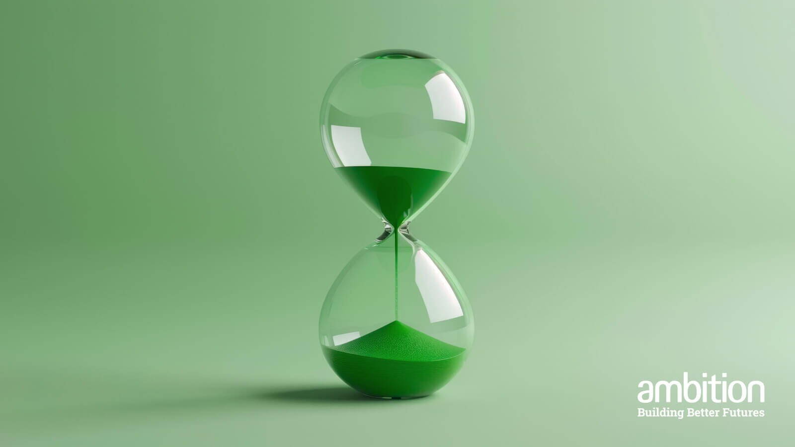 An hourglass with green sand, against a green backdrop.